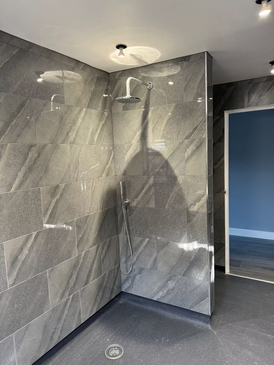 Grey stone-tiled walk-in shower, recently fitted